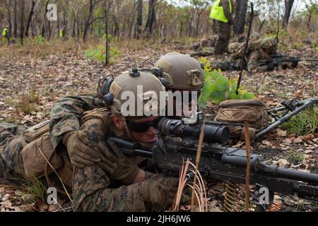 U.S. Marines Corps Lance Cpl. Colton Bailey, and Cpl. Brett Cruson, machine gunners with 3d Battalion, 7th Marine Regiment, Ground Combat Element, Marine Rotational Force-Darwin 22, sight in on an objective during a company attack as part of exercise Koolendong 22 at Mount Bundey Training Area, NT, Australia, July 13, 2022. Exercise Koolendong 22 is a combined and joint exercise focused on expeditionary advanced base operations conducted by U.S. Marines, U.S. Soldiers, U.S. Airmen and Australian Defence Force personnel. (U.S. Marine Corps photo by Cpl Frank Webb) Stock Photo