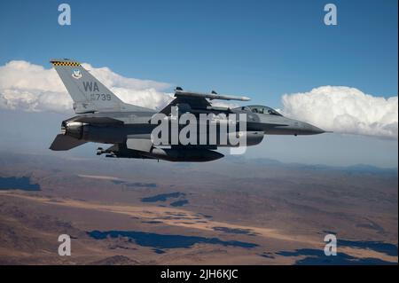 An F-16 Fighting Falcon piloted by Captain Tim “REEF” Joubert, instructor pilot assigned to the 64th Aggressor Squadron, flies over the Nevada Test and Training Range after participating in a Red Flag-Nellis 22-3 mission at Nellis Air Force Base, July 12, 2022. The Nevada Test and Training Range is the U.S. Air Force’s premier military training area with more that 12,000 square miles of air space and 2.9 million acres of land. (U.S. Air Force photo by Senior Airman Zachary Rufus) Stock Photo