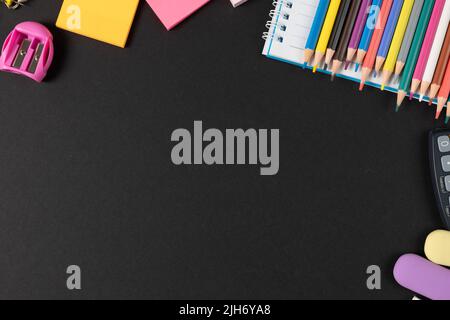 Imagine of various office supplies, pins, rulers, scissors on and calculator on black background Stock Photo