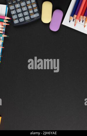 Imagine of various office supplies, pins, rulers, scissors on and calculator on black background Stock Photo