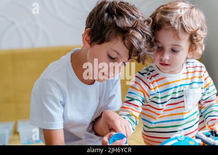 Kid collects robot from plastics details and programmed on tablet, robotics. Stock Photo