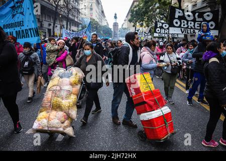 Buenos Aires, Argentina. 14th July, 2022. Two protesters march with their store items as they head to the Mayo Square. Organizations that make up the Picketers Unit carried out a national day of struggle, with protests and mobilizations against the adjustment of the International Monetary Fund. In Buenos Aires, the march went to Plaza de Mayo, demanding an increase in the minimum, vital and mobile wage, and a bonus of $20,000 for retirees, informal workers and beneficiaries of social programs. Credit: SOPA Images Limited/Alamy Live News Stock Photo