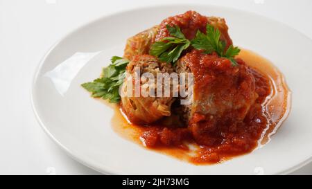 Stuffed cabbage rolls with tomato sauce and herbs Stock Photo