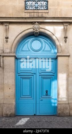 Paris, an old wooden door, with a head carved on the lintel, typical building in the Marais Stock Photo