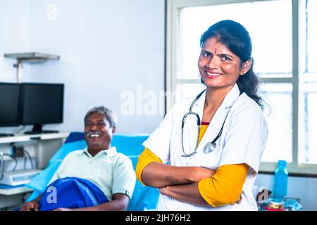 Happy smiling doctor crossed arms in front of patient by looking at camera at hospital - concept of professional occupation, confident and health care Stock Photo