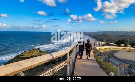People walking along path at Cape Byron with view over Tallow Beach at Byron Bay in NSW Australia Stock Photo