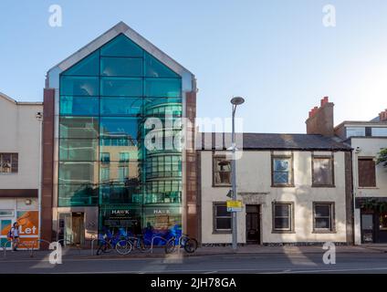Juxtaposition of luxury estate agency in refurbished glass fronted warehouse and derelict house next door Stock Photo