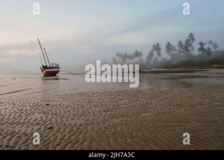 A photograph of a loan sailing dhow beached at a small secluded bay in Vilanculos Mozambique. Stock Photo