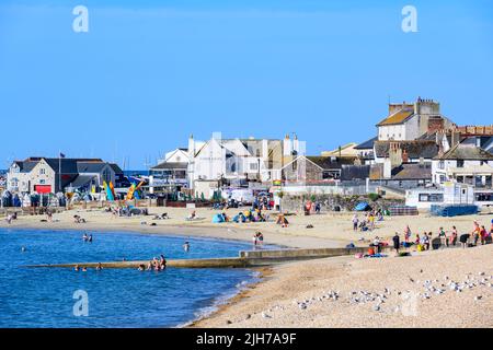 Lyme Regis, Dorset, UK. 16th July, 2022. UK Weather: Holidaymakers and locals soak up the morning sunshine at the seaside resort of Lyme Regis. People were already enjoying the heat by 8am as many arrived early to secure a spot on the beach. Credit: Celia McMahon/Alamy Live News Stock Photo