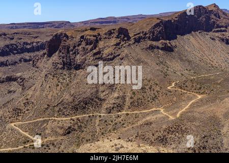 aerial view of the mountains of Gran Canaria with a road that goes around the hillside making curves. Spain. Stock Photo