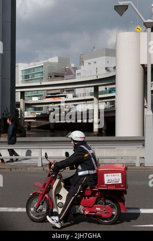 A Japanese postman on a moped.  Nihonbashi, Tokyo, Japan Stock Photo