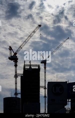 Silhouettes of tower cranes and unfinished buildings at a construction site. Shibuya, Tokyo, Japan. Stock Photo