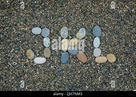letters j k l made from stones in sand on beach Stock Photo