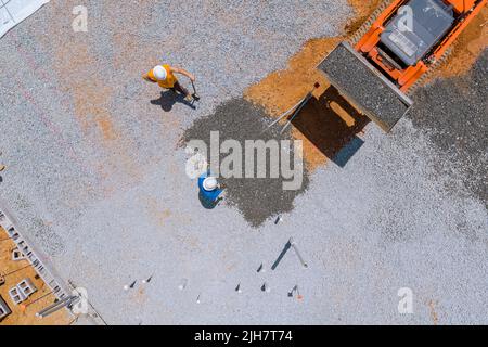 An excavator bucket is used to level gravel on a construction site in order to level Stock Photo