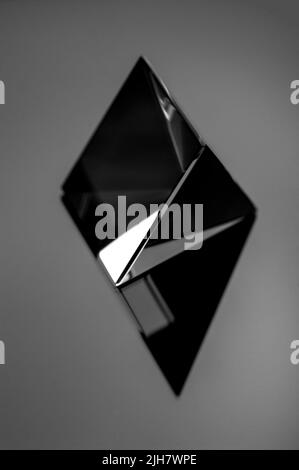 Shiny glass geometric figure in black and white. Black minimal still life image of an abstract shiny object. Stock Photo