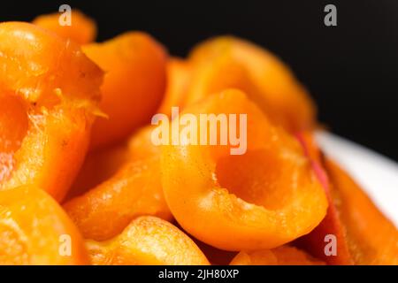 Juicy apricot slices on a black background, side view. Stock Photo