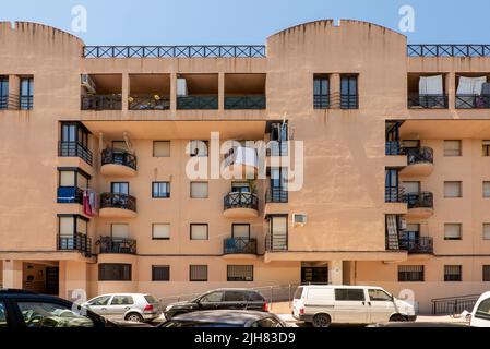 Facades of urban residential houses painted clay vanilla color and windows and black iron Stock Photo