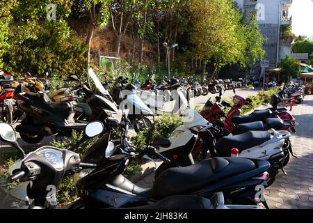 Scooters, motorcycles and mopeds in the street Parking on a Sunny summer day in Turkish resort town. motorcycle parking. Turkey, Marmaris - September Stock Photo