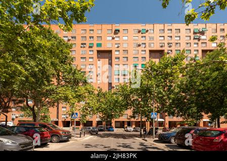 Facades of urban residential houses with clay-colored brick and a view of a garden with trees Stock Photo