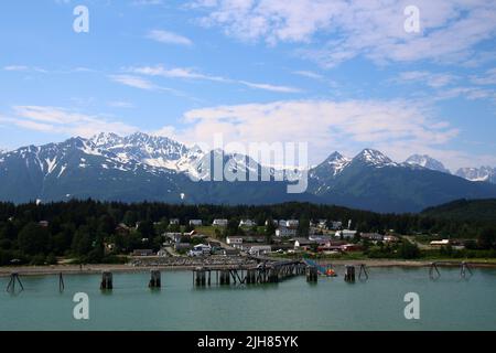 View of Fort William H. Seward from Chilkoot Inlet and mountains in the background, Haines, Alaska, United States Stock Photo