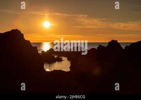 Sunset over rocks, Church Bay, Anglesey, North Wales Stock Photo