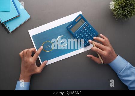 man hand with pen analyzing financial data pov  Stock Photo