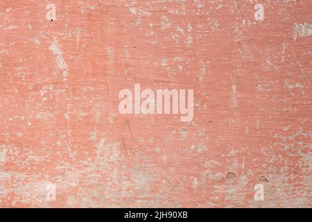 Old distressed wall with worn out salmon pink colored paint, grunge background Stock Photo