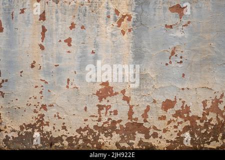 Old rustic mud wall with worn out peeling paint Stock Photo