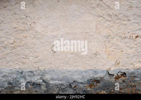 Old distressed lime wash plastered wall with blue skirting board, traditional mediterranean architecture background Stock Photo