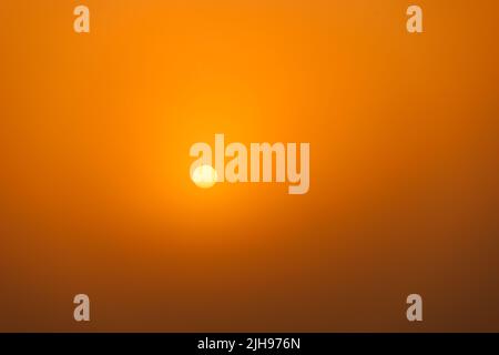 rising sun on clear golden gradient sky without horizon, minimalistic composition Stock Photo