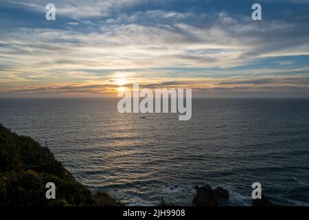 Vibrant orange sunset over the Atlantic Ocean with dramatic cliff silhouette, Cabo da Roca, Sintra, Portugal Stock Photo