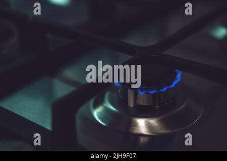 Closeup of blue gas flame on domestic kitchen stove. Gas cooker with burning flames Stock Photo