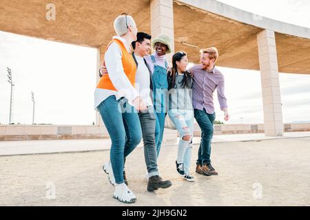 Group of friends having fun together and walking on the street in a sunny day. Stock Photo
