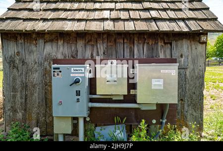 Pump switch and electrical boxes on an old wood building in central Oregon, USA Stock Photo