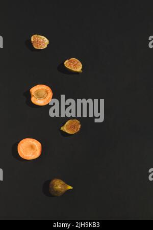 Creative summer layout made of fresh apricot and figs on black background. Flat lay. Food concept. Stock Photo