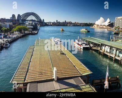 Sydney's Circular Quay wharves 6 & 5 on Sydney Cove with harbour ferries, the Harbour Bridge and Opera House in the background. Stock Photo