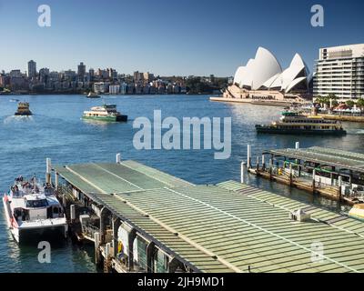 Sydney's Circular Quay wharves 5 & 4 on Sydney Cove with harbour ferries, the Harbour Bridge and Opera House at Bennelong Point in the background. Stock Photo