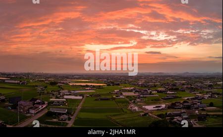 Dramatic clouds at sunset over rural farming community in rural Japan Stock Photo