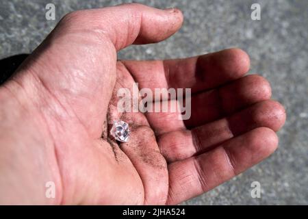 Hand with a simulated diamond pretending to have been found on earth Stock Photo