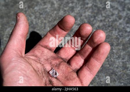 Hand with a simulated diamond pretending to have been found on earth Stock Photo