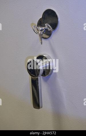 Lock and key on the door of a safe Stock Photo