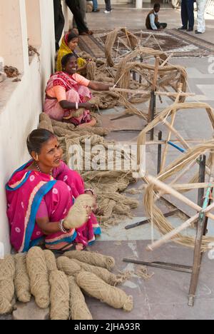 Smiling Indian man weaver or worker creating traditional fabric on a ...