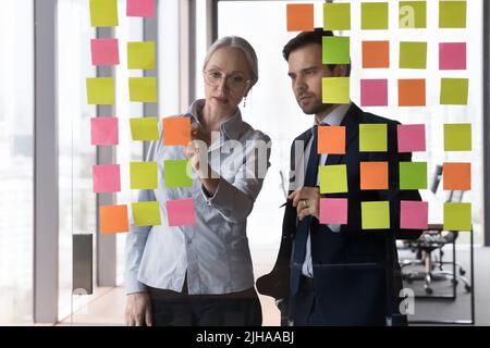 Two serious focused business colleagues working on project together Stock Photo