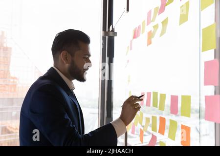 Happy busy Indian businessman making project schedule Stock Photo