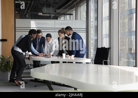 Serious diverse business group meeting at table in modern office Stock Photo