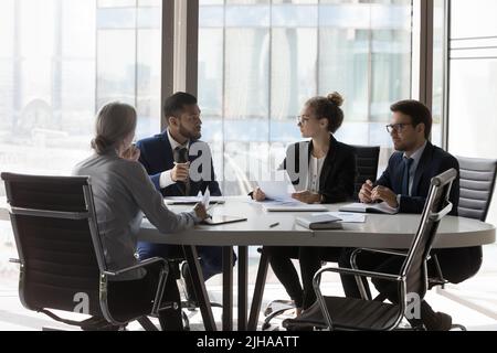 Busy millennial professional group reviewing startup marketing reports Stock Photo
