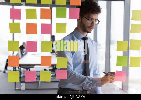 Serious millennial business project team leader man working in office Stock Photo
