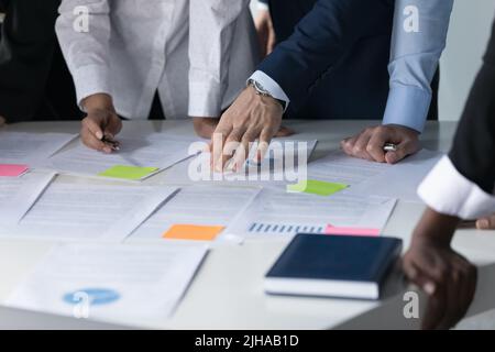 Meeting table and hands of multiethnic business colleagues close up Stock Photo