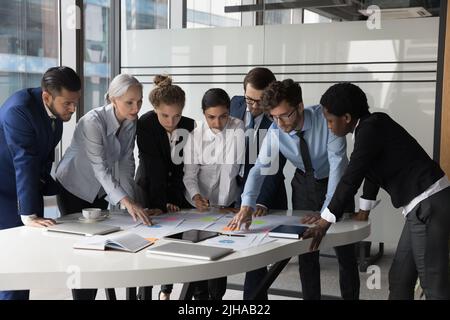 Diverse different aged business group standing at meeting table Stock Photo