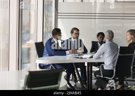 Serious diverse group of business coworkers collaborating on project Stock Photo
